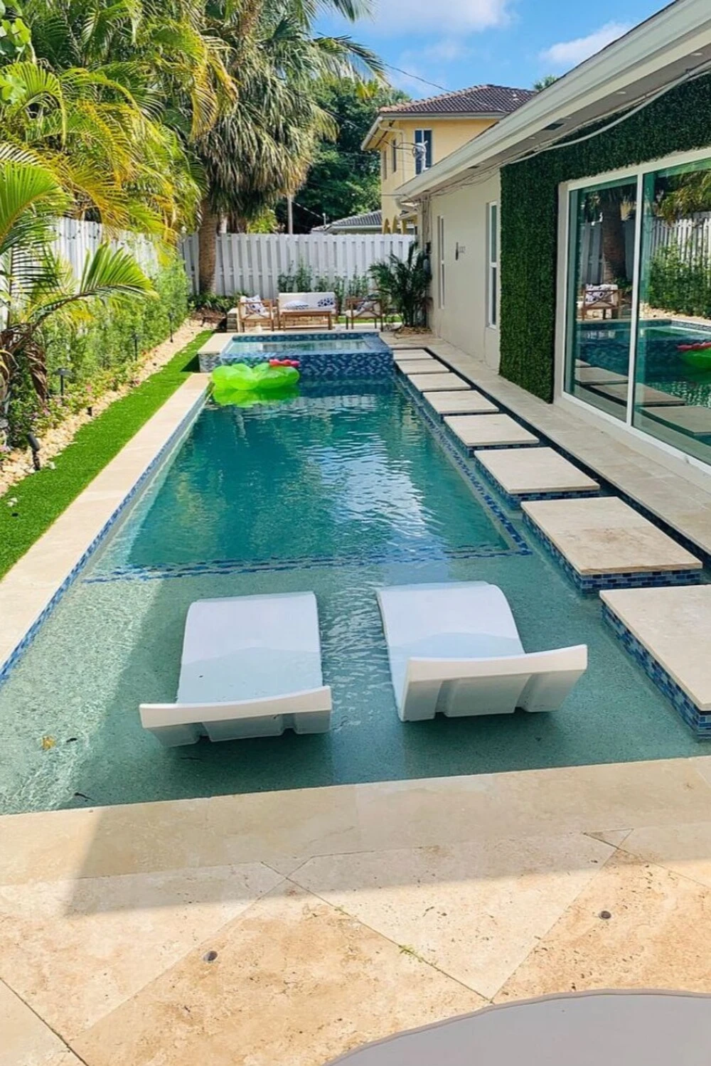 a small backyard pool with baja shelf